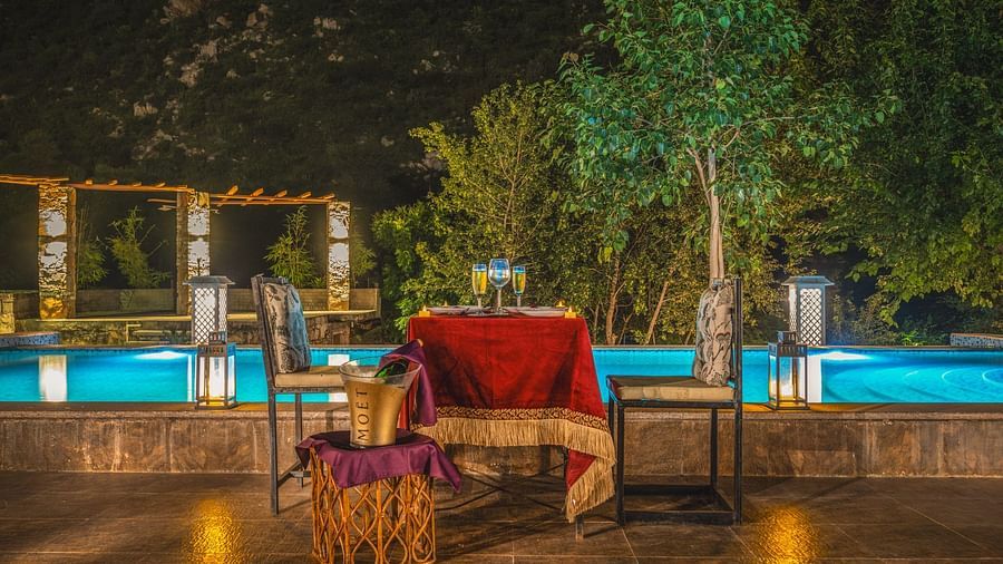 A dining area with a table and chair placed beside a a swimming pool at Valley by Grassfield.