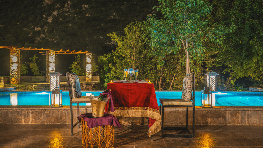 A dining area with a table and chair placed beside a a swimming pool at Valley by Grassfield.