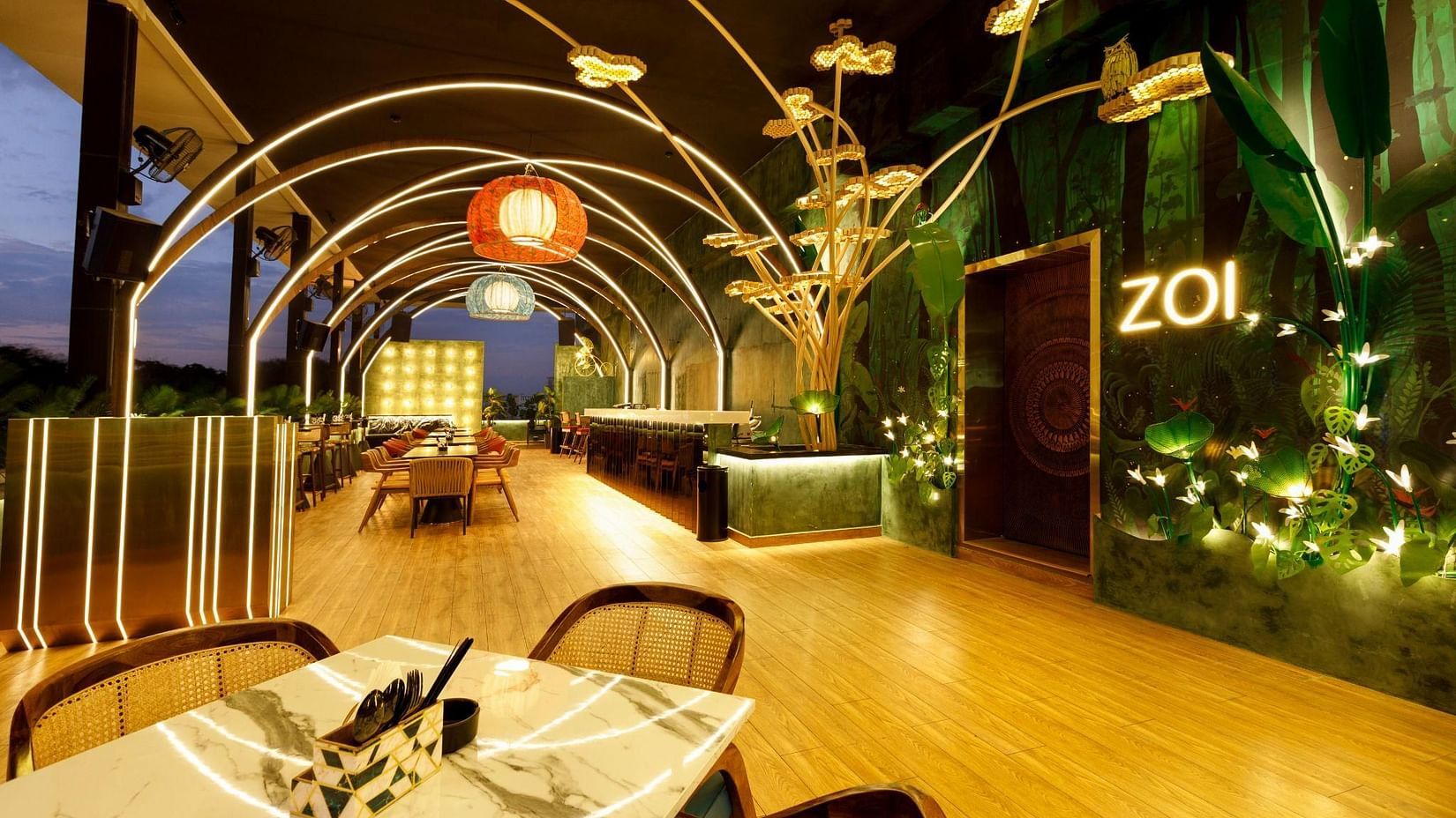 Elegant rooftop dining area at Zoi, Jenneys Residency, featuring ambient lighting and stylish decor for a fine dining experience
