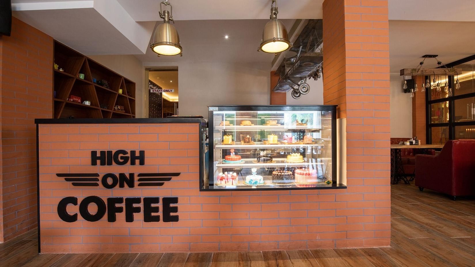 Modern café counter at Jenneys Residency with  High on Coffee signage, offering a cosy space for quick bites and beverages.