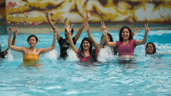 Group of women having fun and cheering in a wave pool.