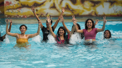 Group of women having fun and cheering in a wave pool.