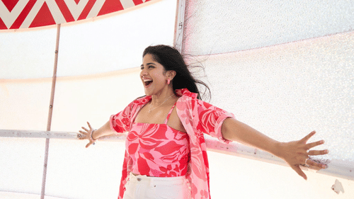 Woman enjoying a thrilling water slide, arms outstretched with joy.