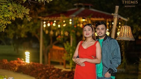 A couple posing for a photo at nightime at Themis Mudhouse- A Nature's Wellness Resort