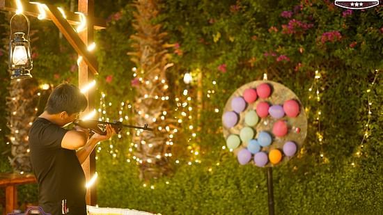 A man shooting at balloons at Themis Mudhouse - A Nature