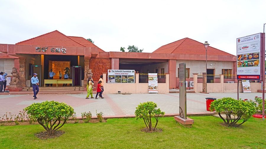 Exterior of Vithal Kamat restaurant with red-roofed building and green lawn at the entrance