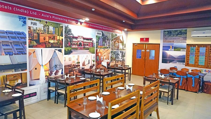 Well-lit Vithal Kamat restaurant interior with family-friendly seating and vivid wall art