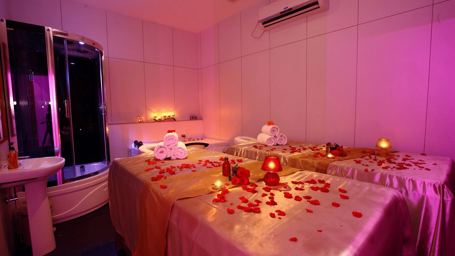 a massage bed with rose petals on them at the in-house spa in Chennai - Raj Park Hotel, Chennai