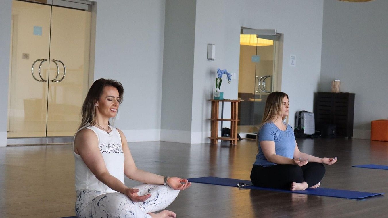 two women meditating indoor on mats