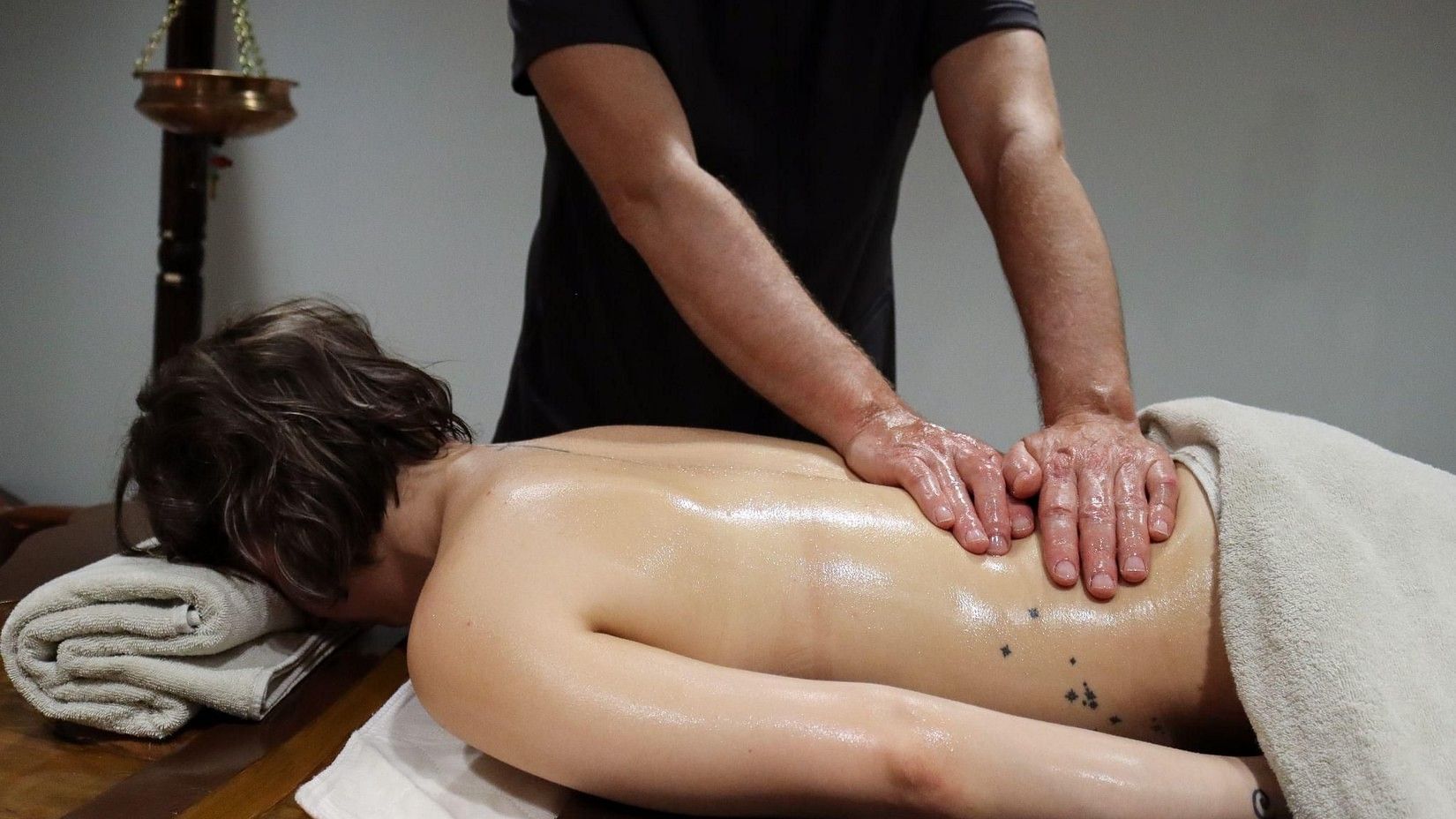 A person receiving an Ayurvedic oil massage on the back, with herbal oils and expert hands at YO1 Longevity and Health Resorts