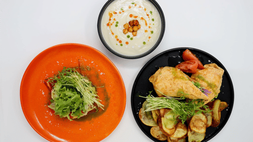 Three colorful plates of food on a white surface, featuring a creamy soup, leafy salad, and a main dish with vegetables at YO1 Longevity and Health Resorts, Catskills