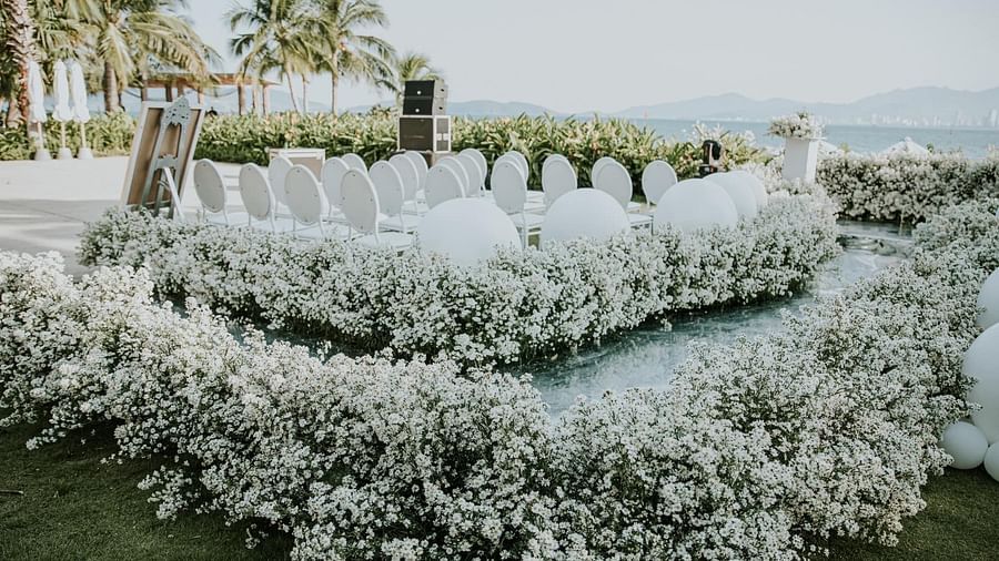 An altar at our lawn surrounded by flowers and chairs placed on an elevated platform - Alibu Resort Nha Trang