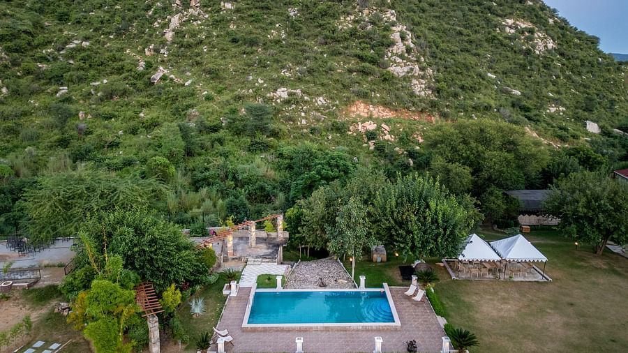 Aerial view of a swimming pool surrounded by plants and mountian in the background at Valley by Grassfield.