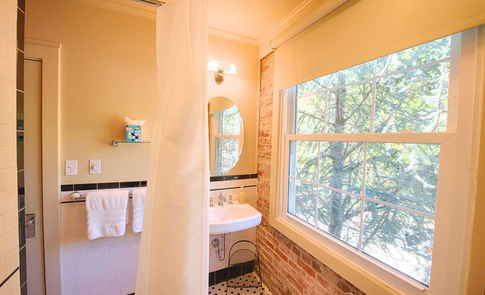 a bathroom with bricked wall along with a wide window throwing ample of natural sunlight in the room - Historic Tapoco Lodge