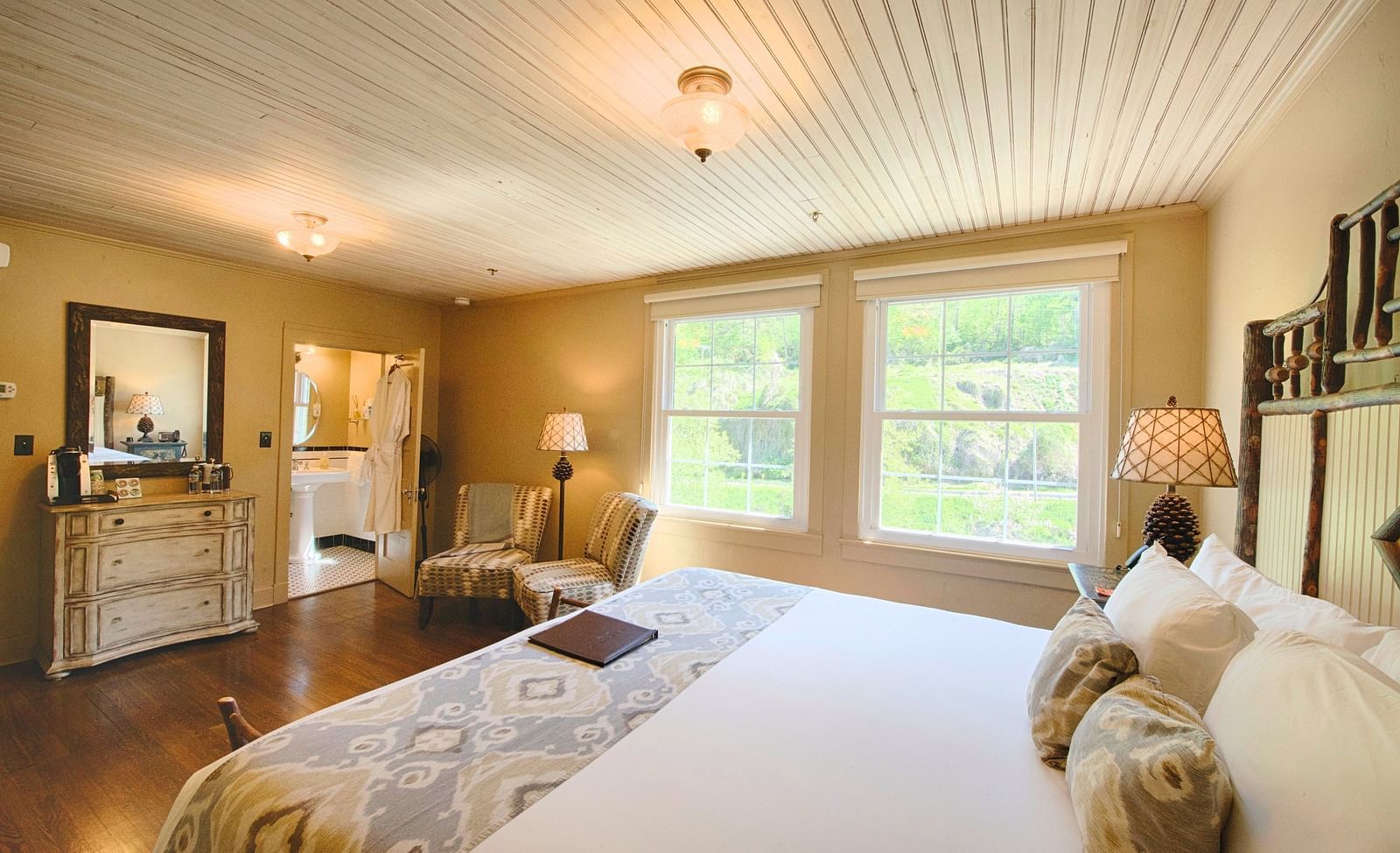 a bright bedroom with ample of natural light coming form the windows beside the double bed - Historic Tapoco Lodge