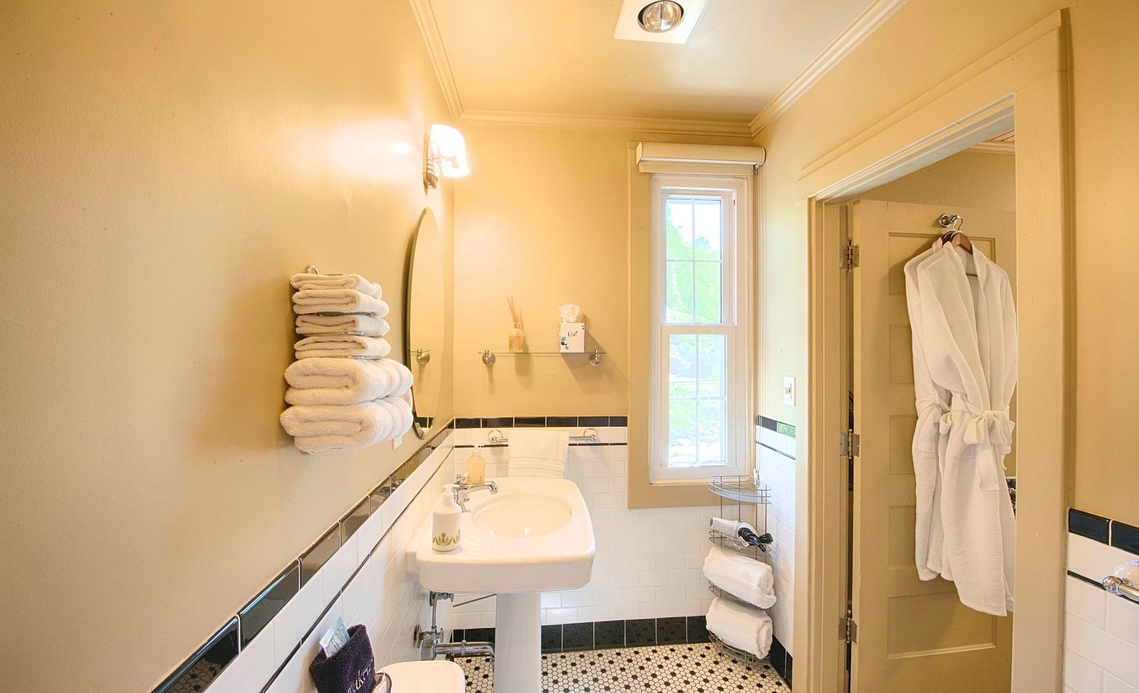 a small bathroom with a wash basin with fresh towels staked besides it - Historic Tapoco Lodge