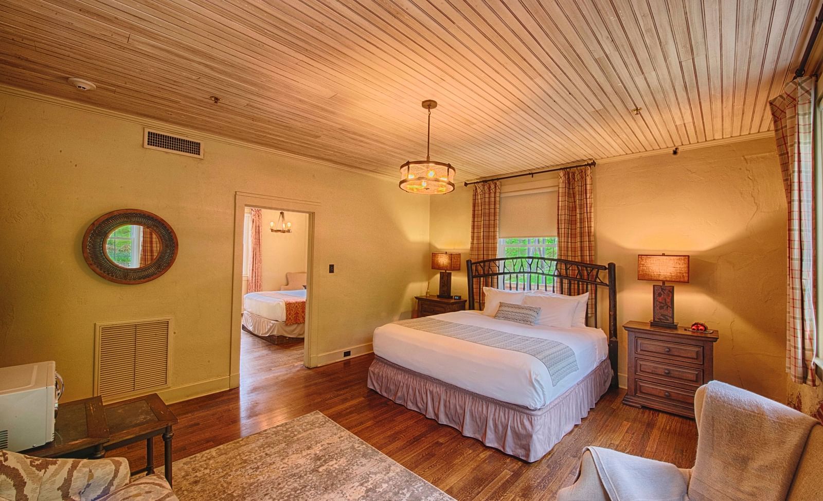 full view image of the evergreen suite featuring a double bed and a small window behind it - Historic Tapoco Lodge
