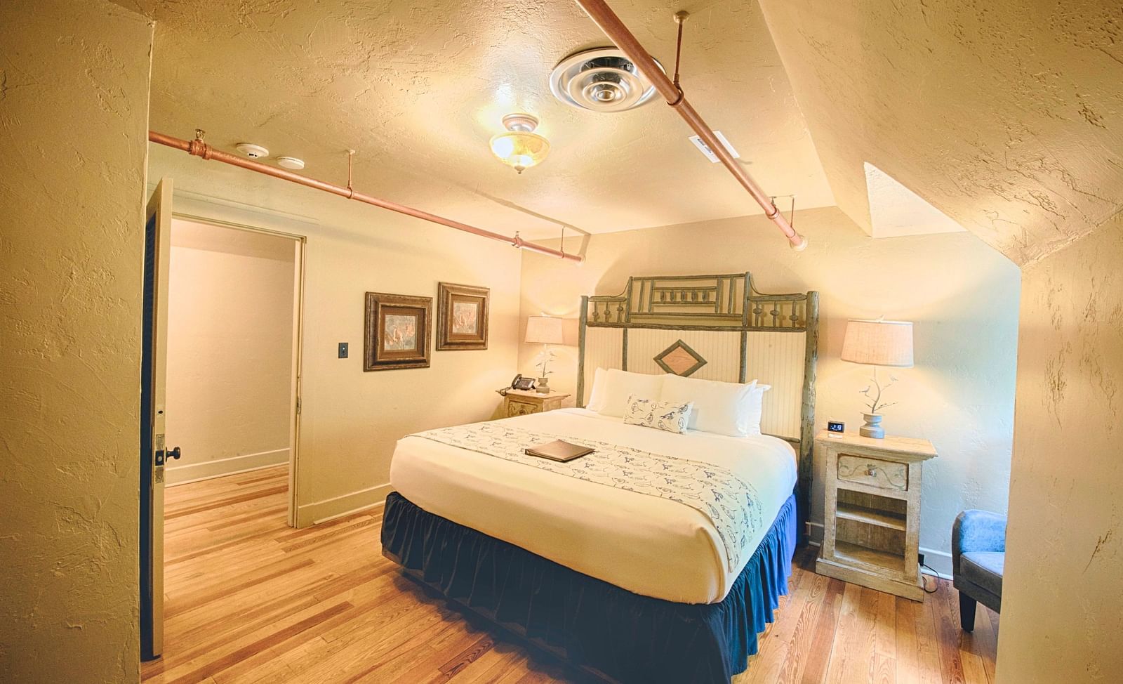 full view image of the bedroom of rhododendron suite featuring a huge double bed with bedside table beside it - Historic Tapoco Lodge