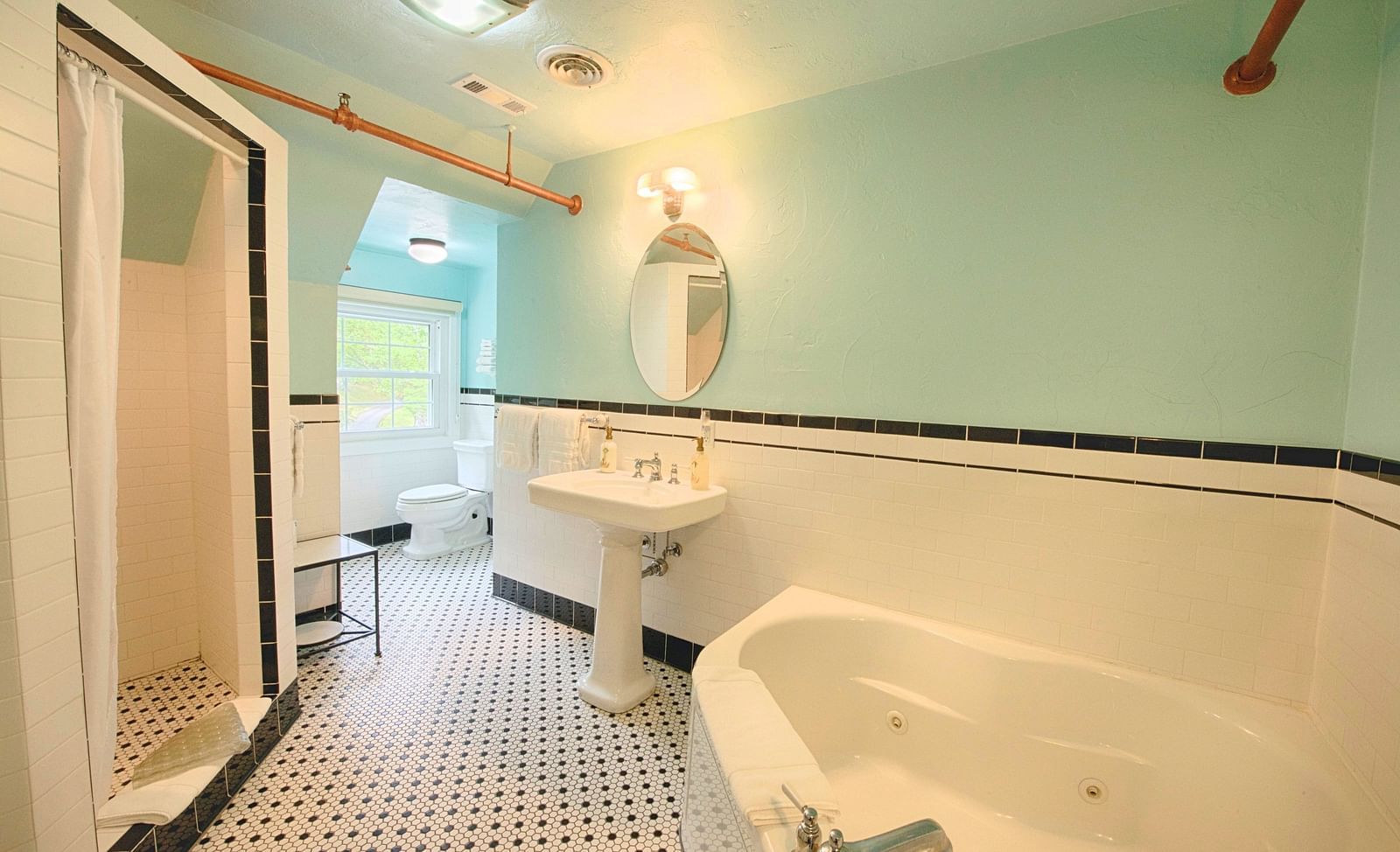 a chic and modern bathroom at the laurel suite featuring a big bath tub along with a shower cubical and a wash basin - Historic Tapoco Lodge