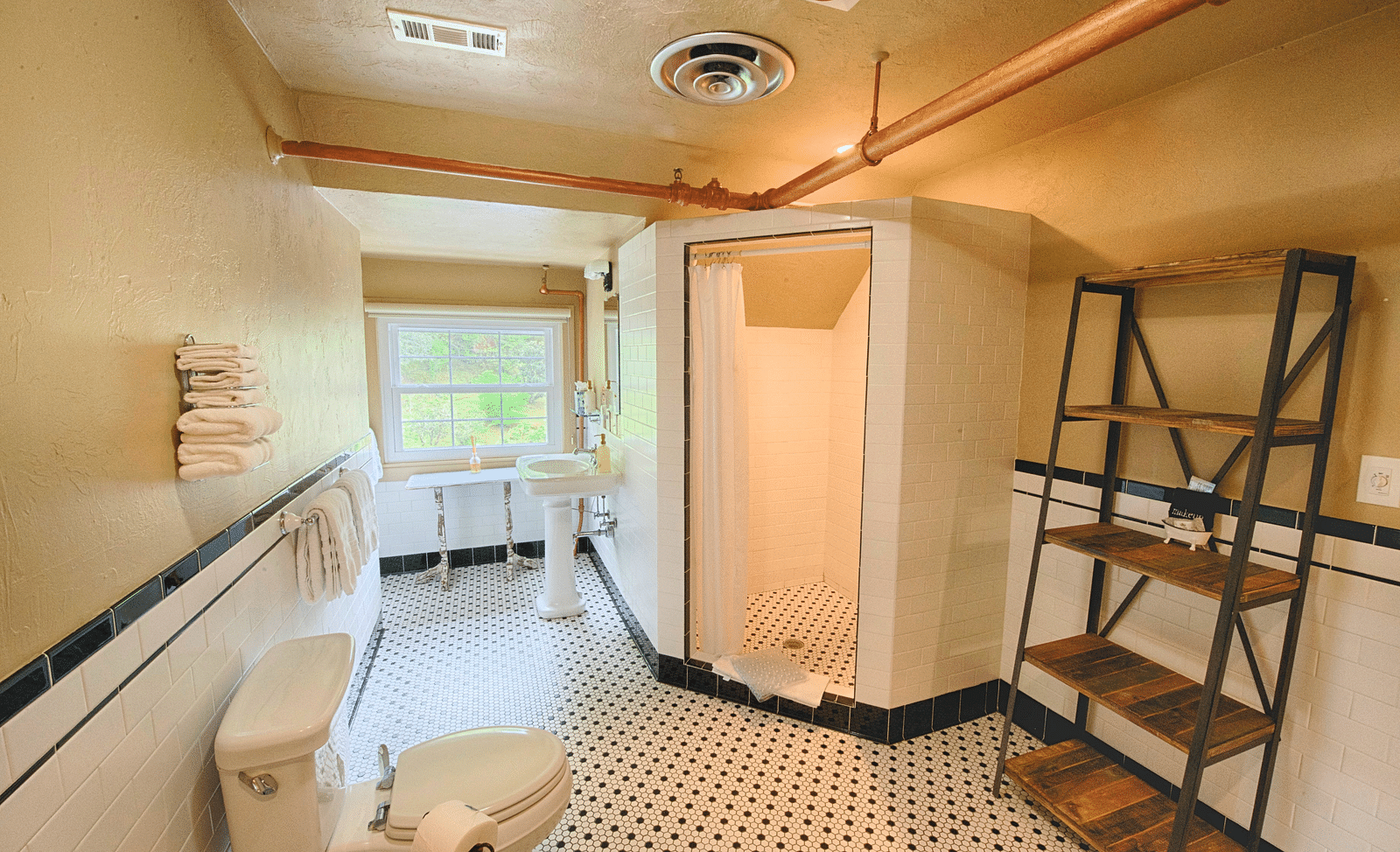 full view image of a bathroom with a shower cubical along with a wooden shelf and a commode - Historic Tapoco Lodge