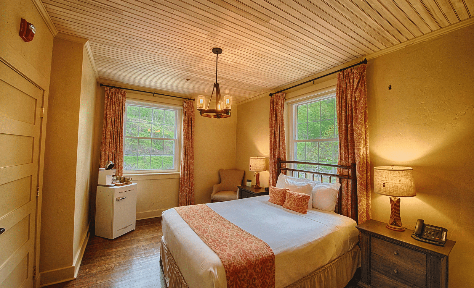 full view image of a bedroom with two huge windows with open curtains - Historic Tapoco Lodge