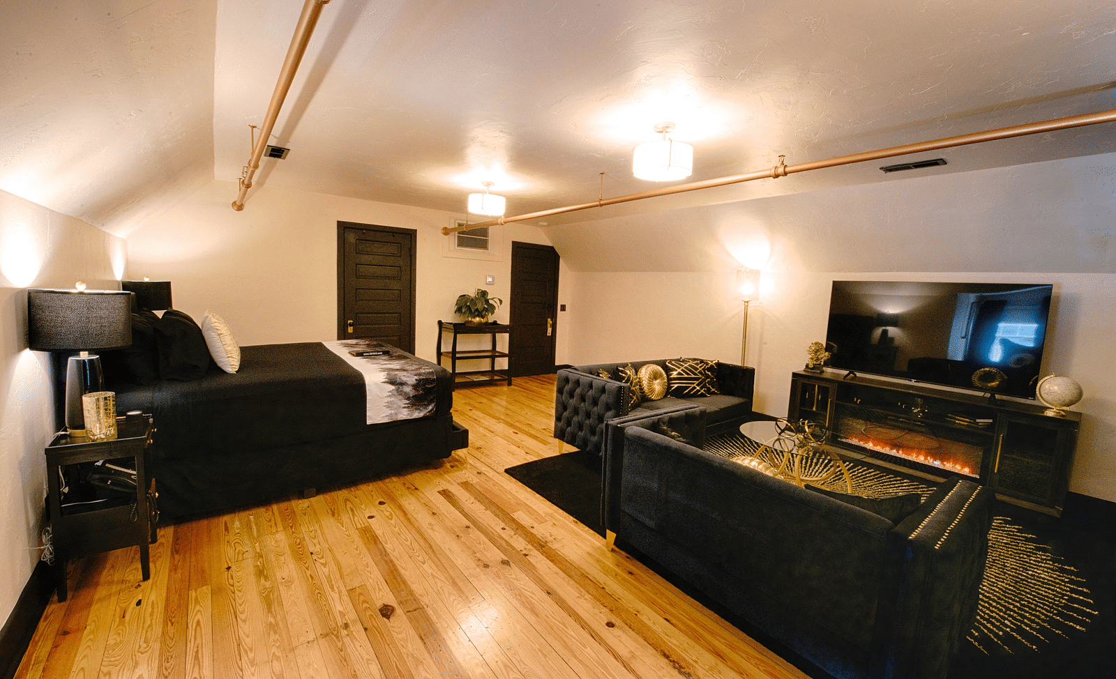 full view image of the roosevelt suite featuring black colored furnishings along with white walls - Historic Tapoco Lodge