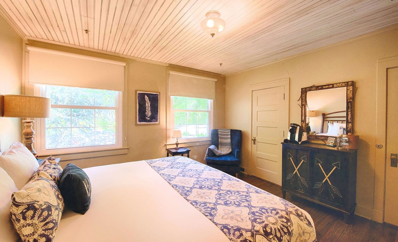 full view image of a cozy bedroom with a comfortable double bed and a wooden cabinet along with a mirror above it - Historic Tapoco Lodge