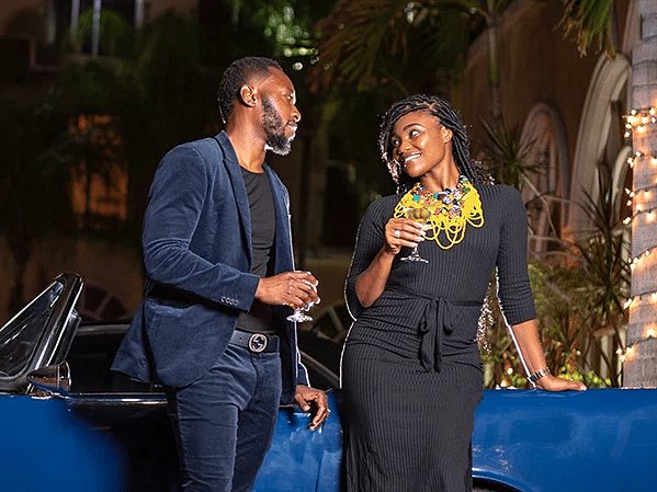 A couple enjoying drinks beside a vintage car - S Hotel Kingston, Jamaica