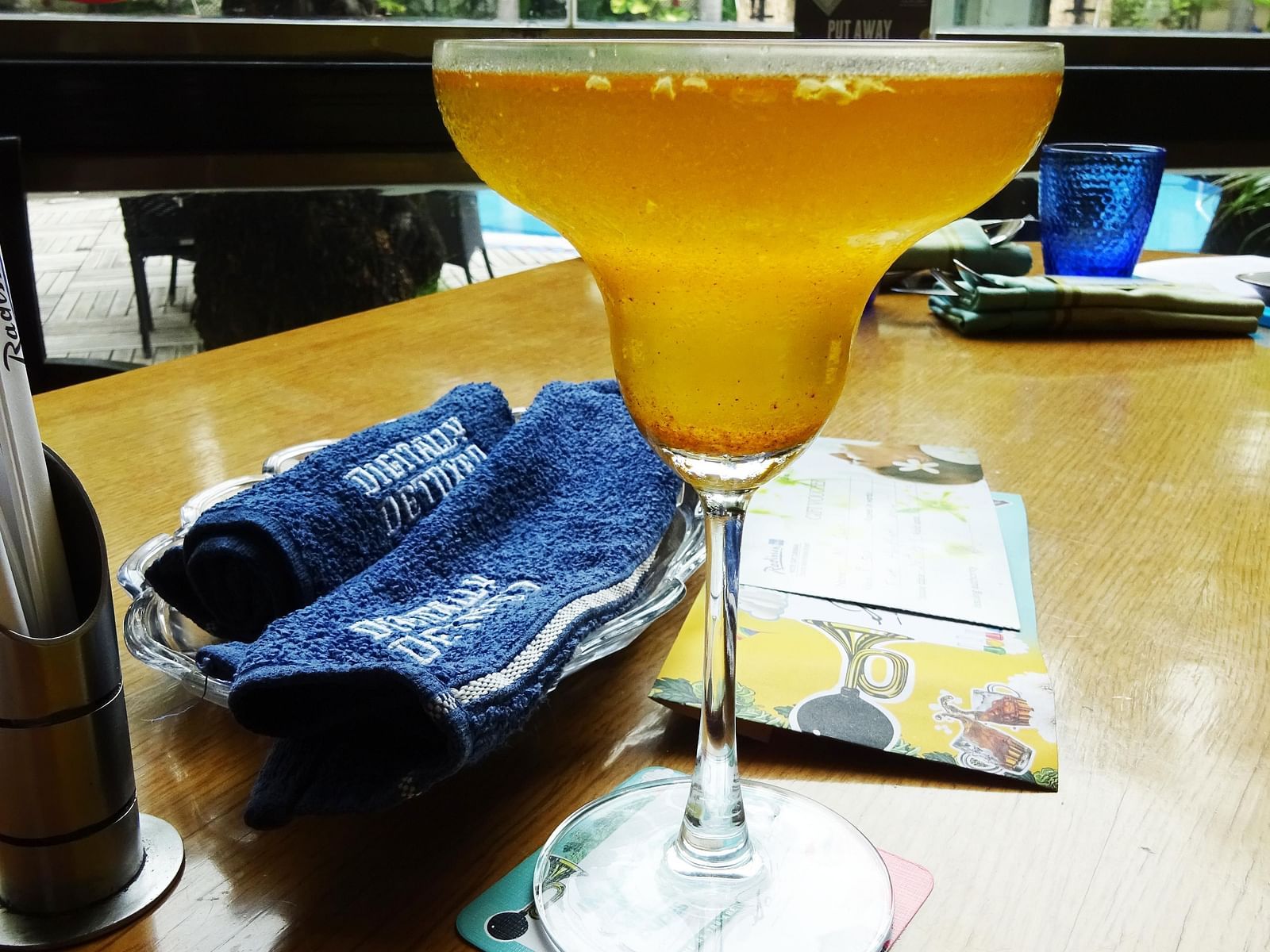Cocktail served in a glass with a blue napkin and an outdoor view