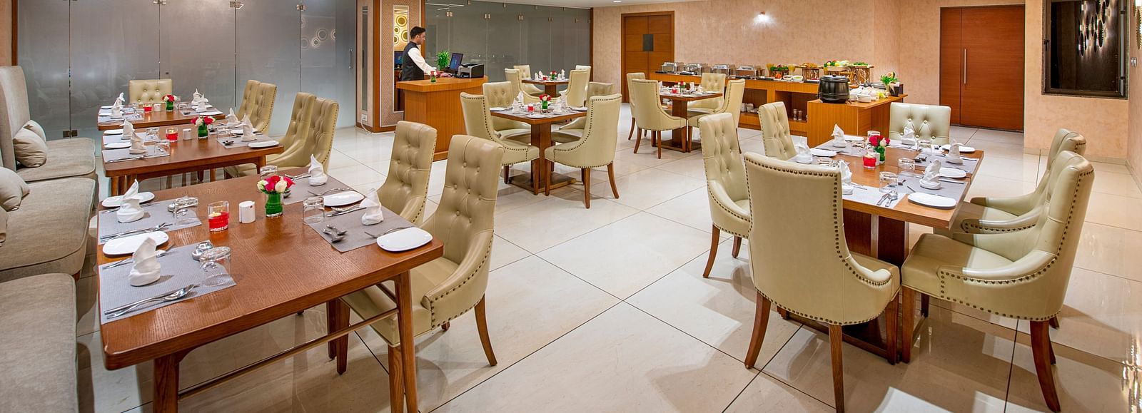 A hotel dining area with wooden tables and comfortable chairs, ready for guests to dine - SK Lords Inn Ahmedabad