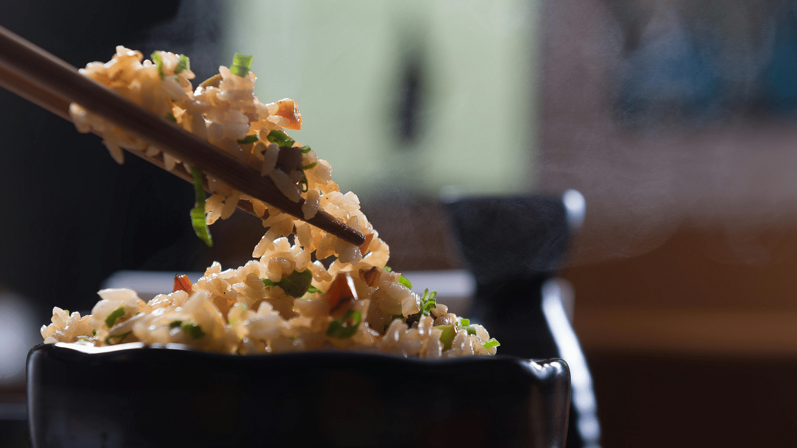 image of a chinese food preparation picked up by a pair of chopsticks