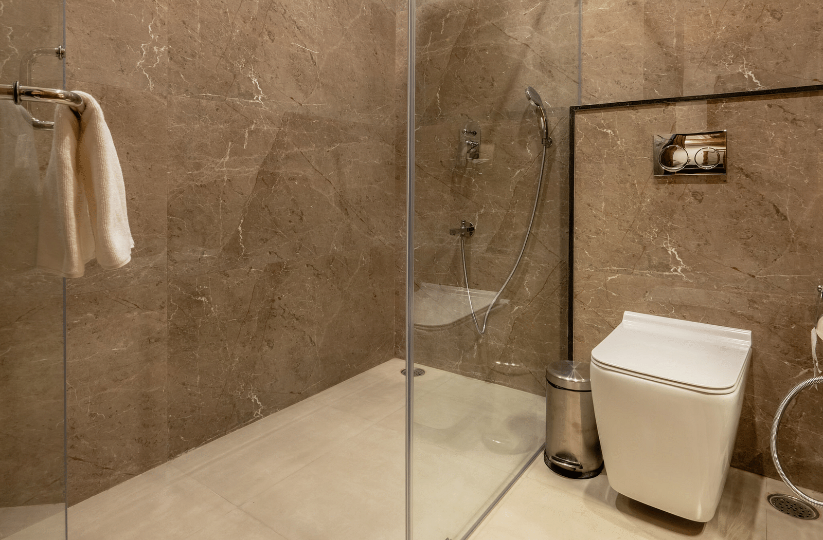 a modern bathroom with a separate showering area separated by a glass partition - Brij Castle, Jaipur