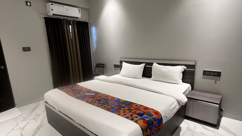 A hotel bedroom with a large bed under a ceiling fan at VITS Select Kharadi, Pune.