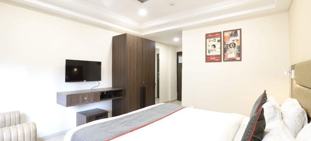 Corner view shot of the Premium Room featuring a double bed with a grey bed runner spread over it at Pravasa Ahmedabad.
