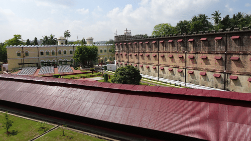 An overview of cellular jail in port blair with trees and blue sky in the background. It is the location of Light and Sound Show Port Blair.