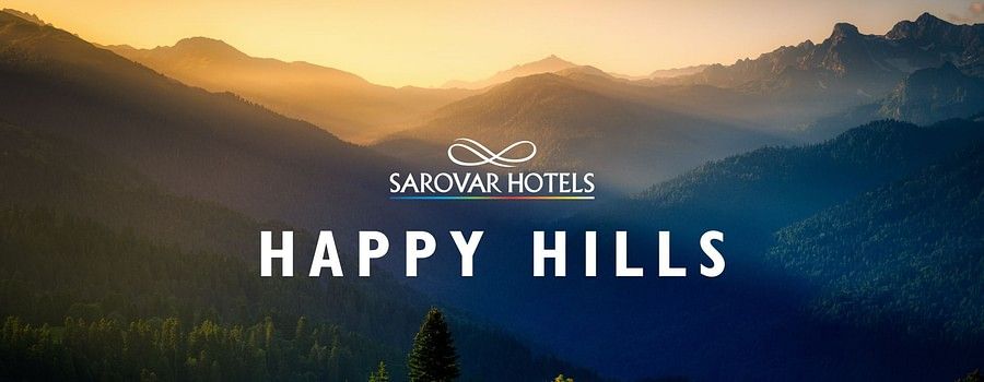 Golden sunset over scenic mountain hills with the text Sarovar Hotels, Happy Hills