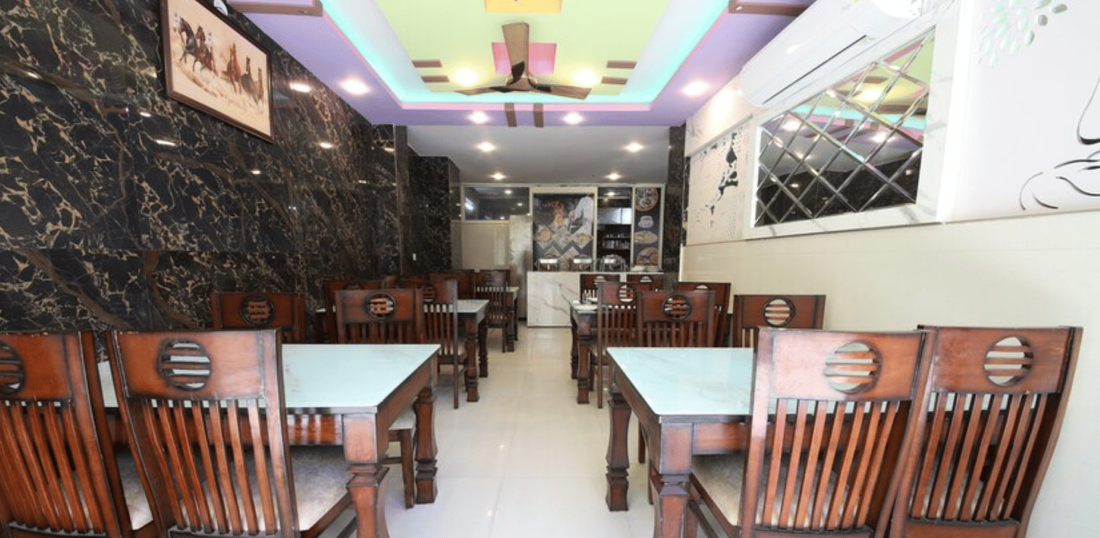 A dining area with neatly arranged wooden chairs around square dining tables | Perfectstayz Value Hills, Rishikesh