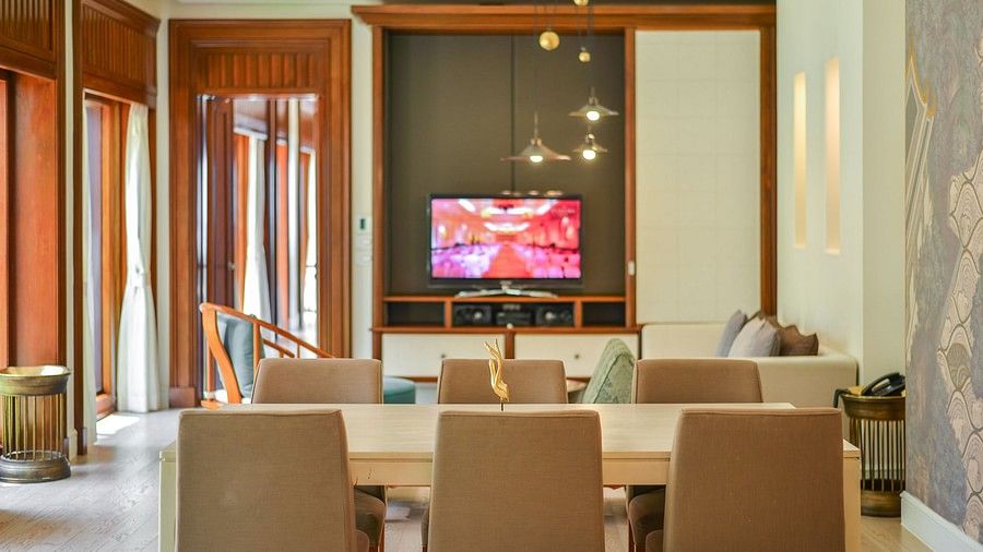 image showcasing a switched on television and a dining area - one bedroom private pool beachfront villa