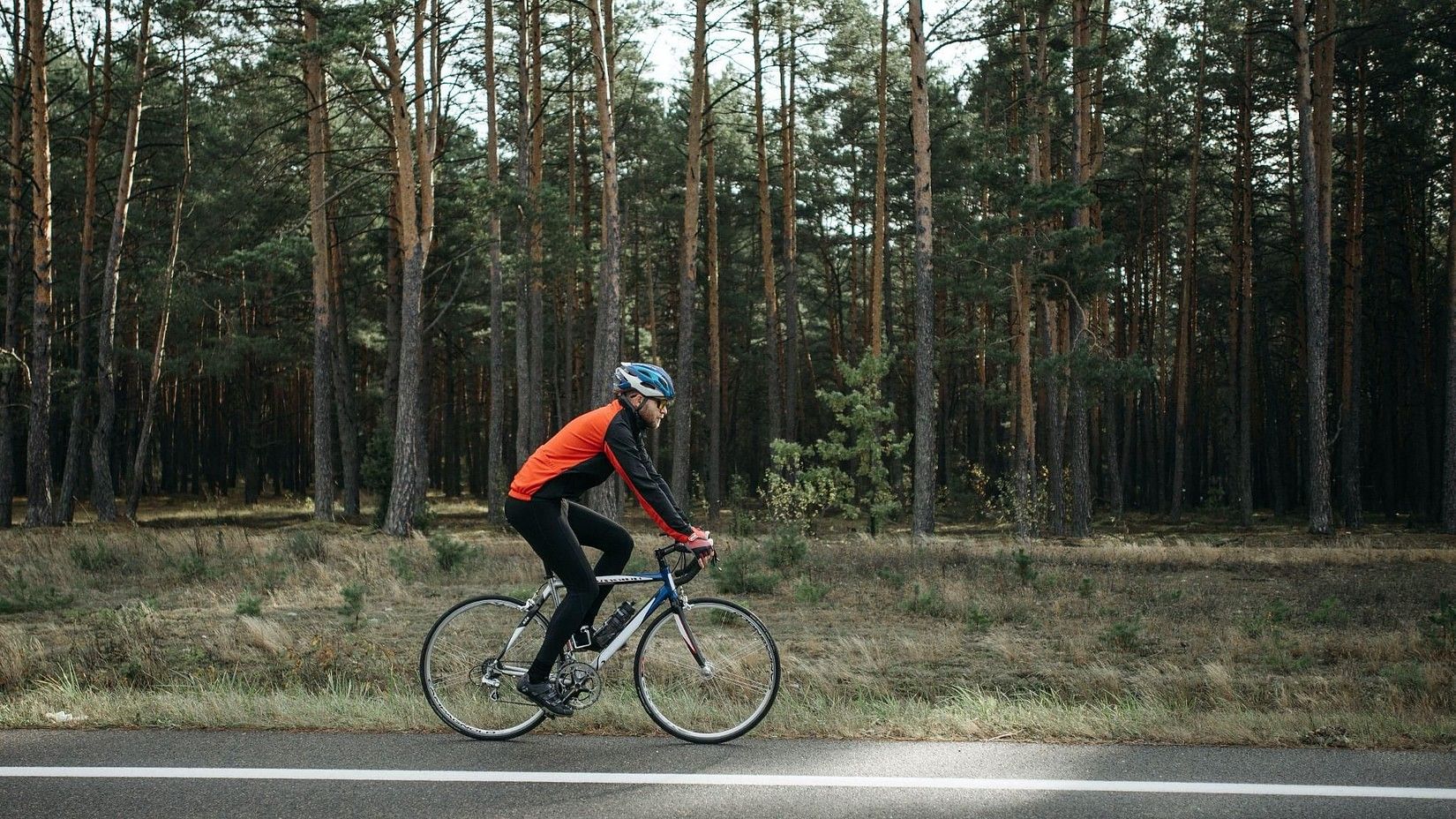 a person riding bicycle by the woods