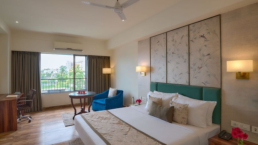 Cosy twin-bed Superior Room at Voyage Milestone Hotel and Banquet with a patterned accent wall, wooden flooring, and balcony access.