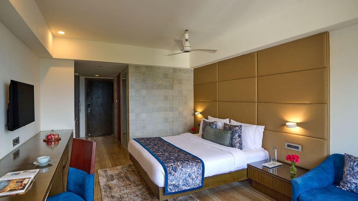 Premium Room at Voyage Milestone Hotel and Banquet featuring a plush bed, stylish interiors, flat-screen TV, and comfortable lounge chairs.