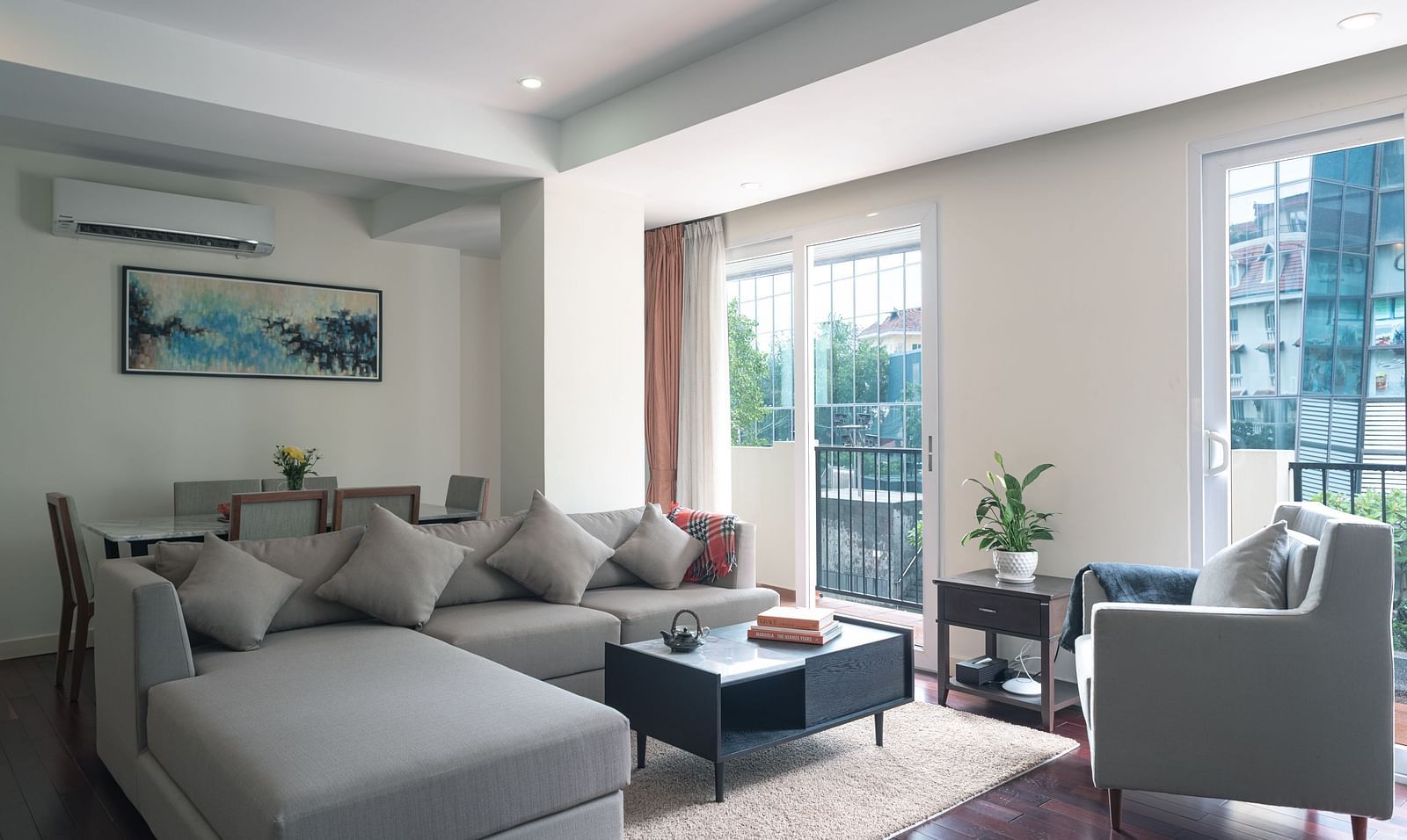 A living room with a sofa, a coffee table, an armchair, and a window with a view | Three-bedroom Suite | Central Mansions, Phnom Penh