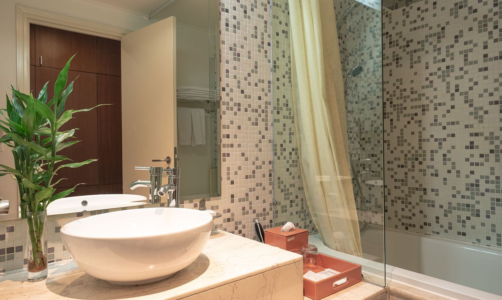 A bathroom with a modern sink, a mirror, and a tiled shower | Three-bedroom Suite | Central Mansions, Phnom Penh