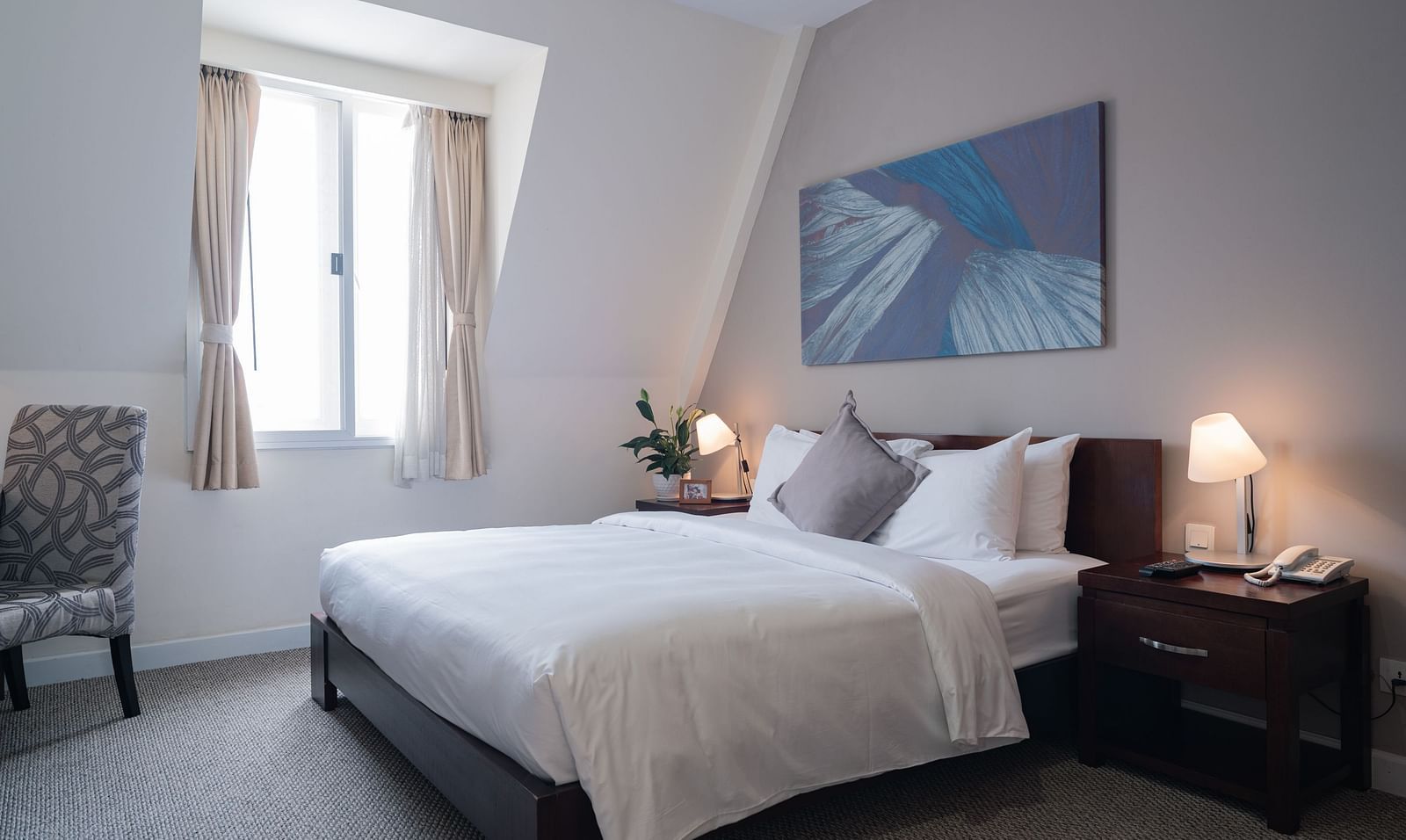 A bedroom with a large bed and a large window near it | Studio | Central Mansions, Phnom Penh