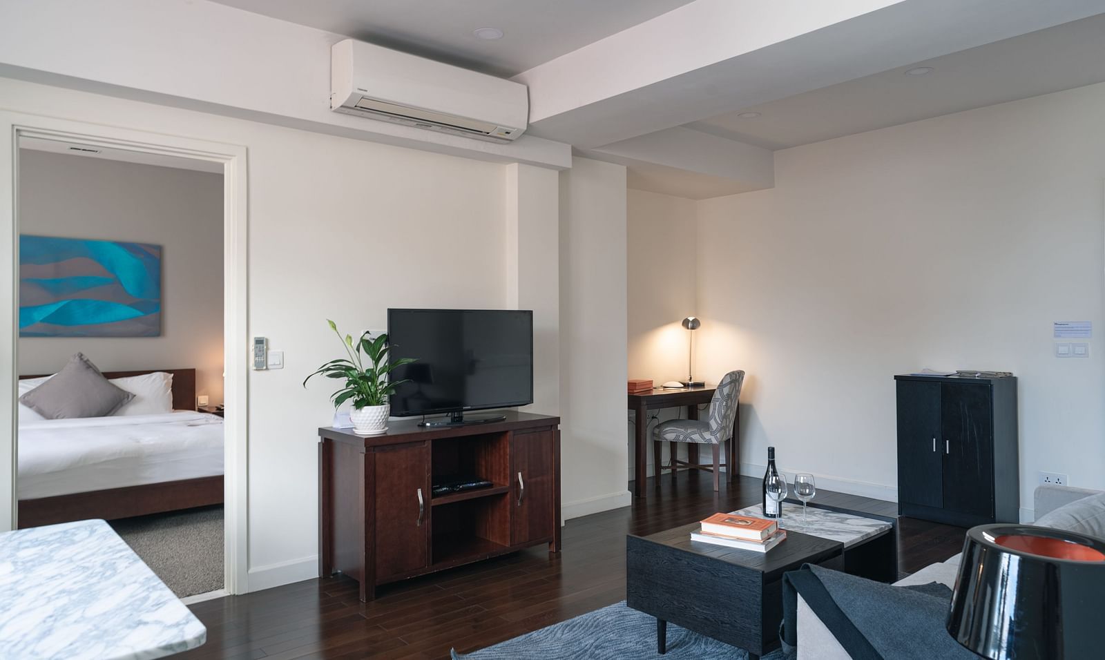 A bedroom with a bed, a television, and a chair | One-bedroom Suite | Central Mansions, Phnom Penh