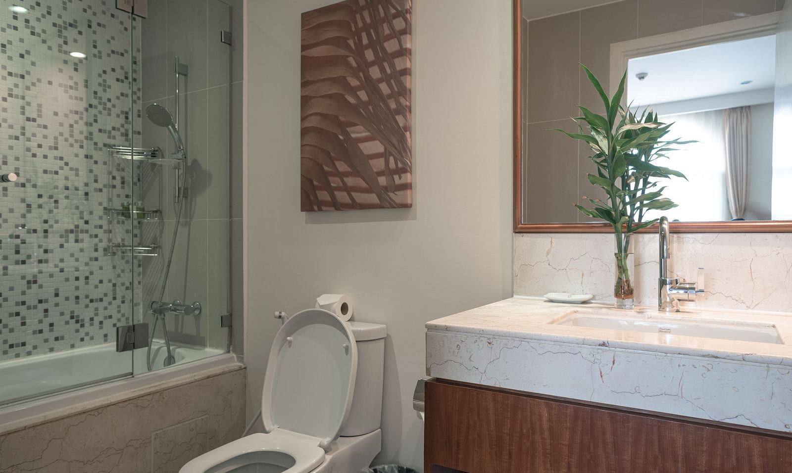 A bathroom with a sink, a mirror, and a toilet | One-bedroom Suite | Central Mansions, Phnom Penh