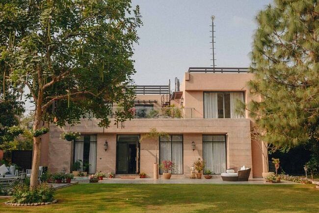 Exterior view of a villa building with a large lawn and trees surrounding it at Karma Chalets.