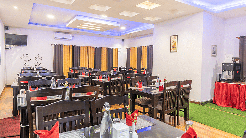 A dining space with napkins placed on the table at Coorg Jungle Camp Backwater Resort, Kushalnagar.