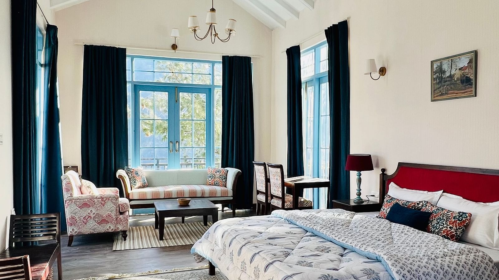 Side view of Superior Luxury Cottage with bed, slanted ceiling and rug by the foot of the bed | Faraway Cottages, Auli