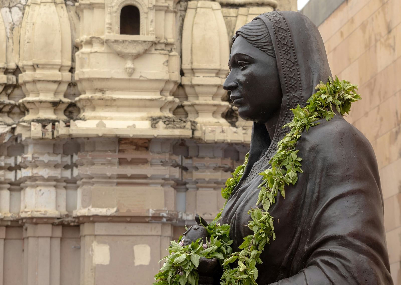 An overview of Alihyabai Holkar's statue in front of a old building.